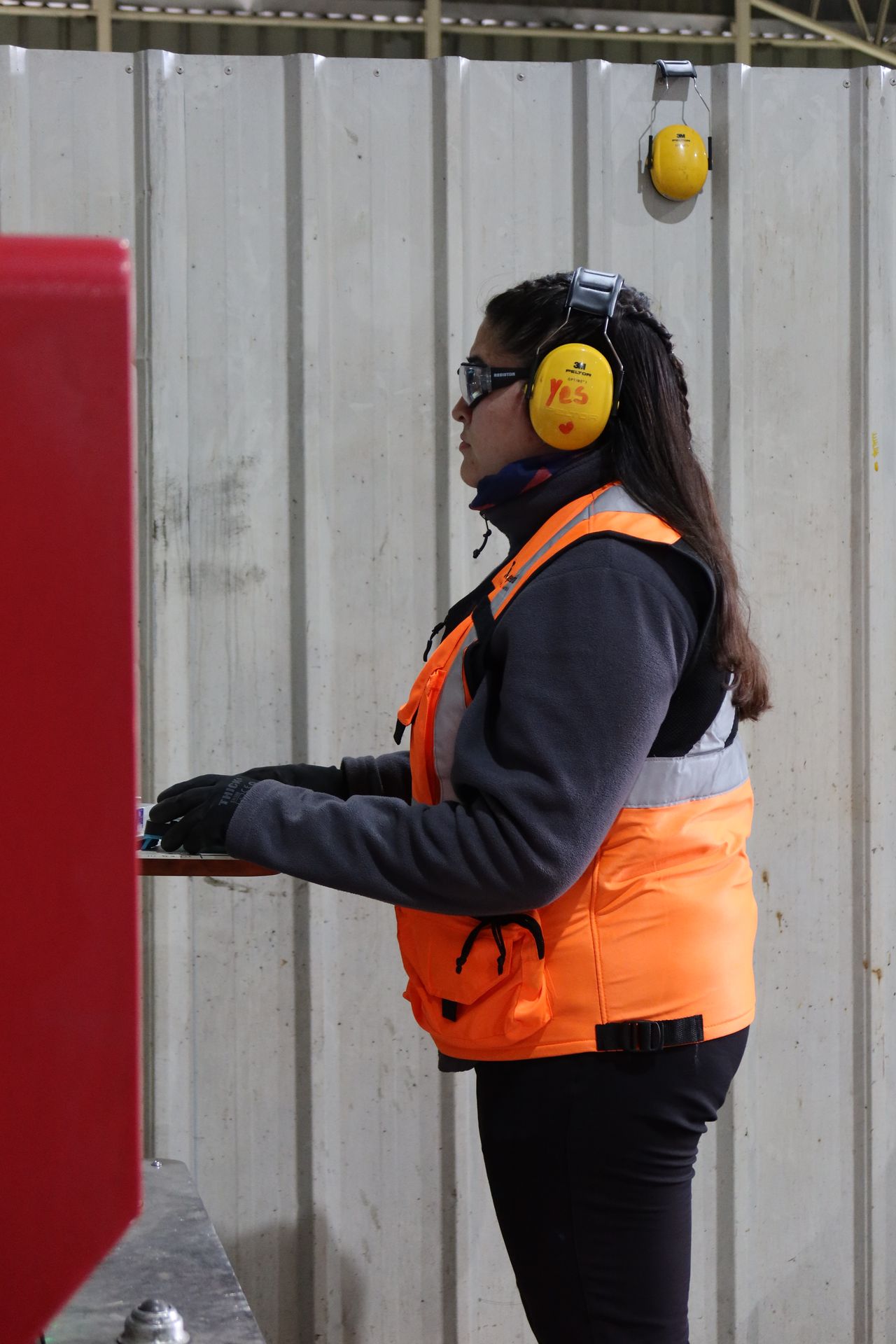 Técnico de R Ingeniería con equipo de protección personal operando la grúa horquilla